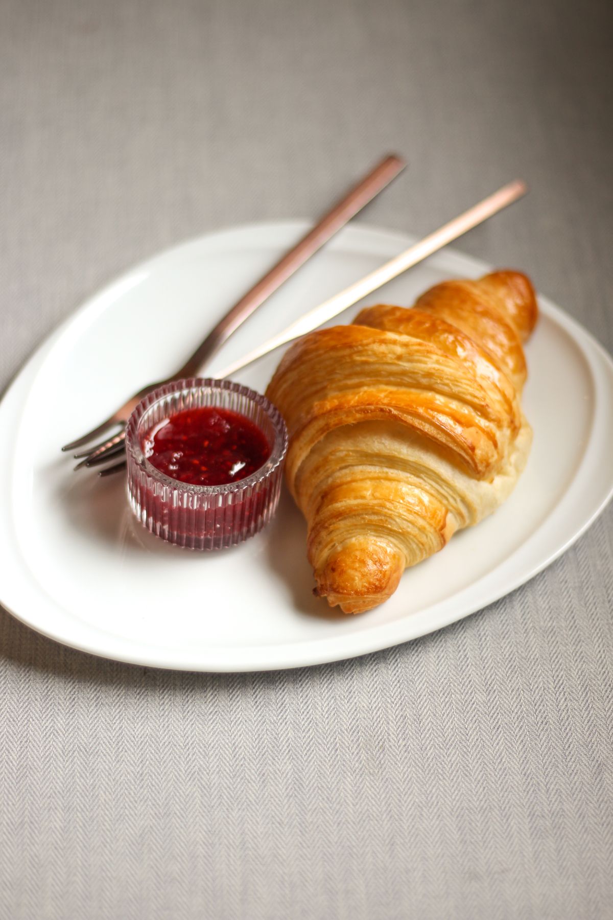 Croissant au beurre bien feuilleté, servi avec une confiture maison