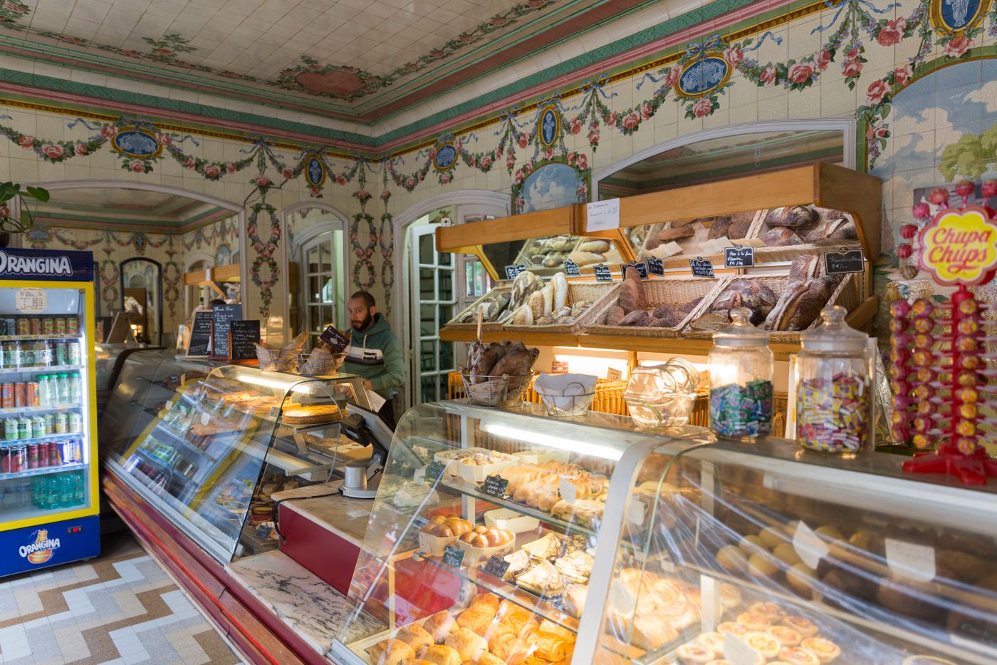 L'intérieur de la boulangerie, ses vitrines garnies et ses casiers de pain