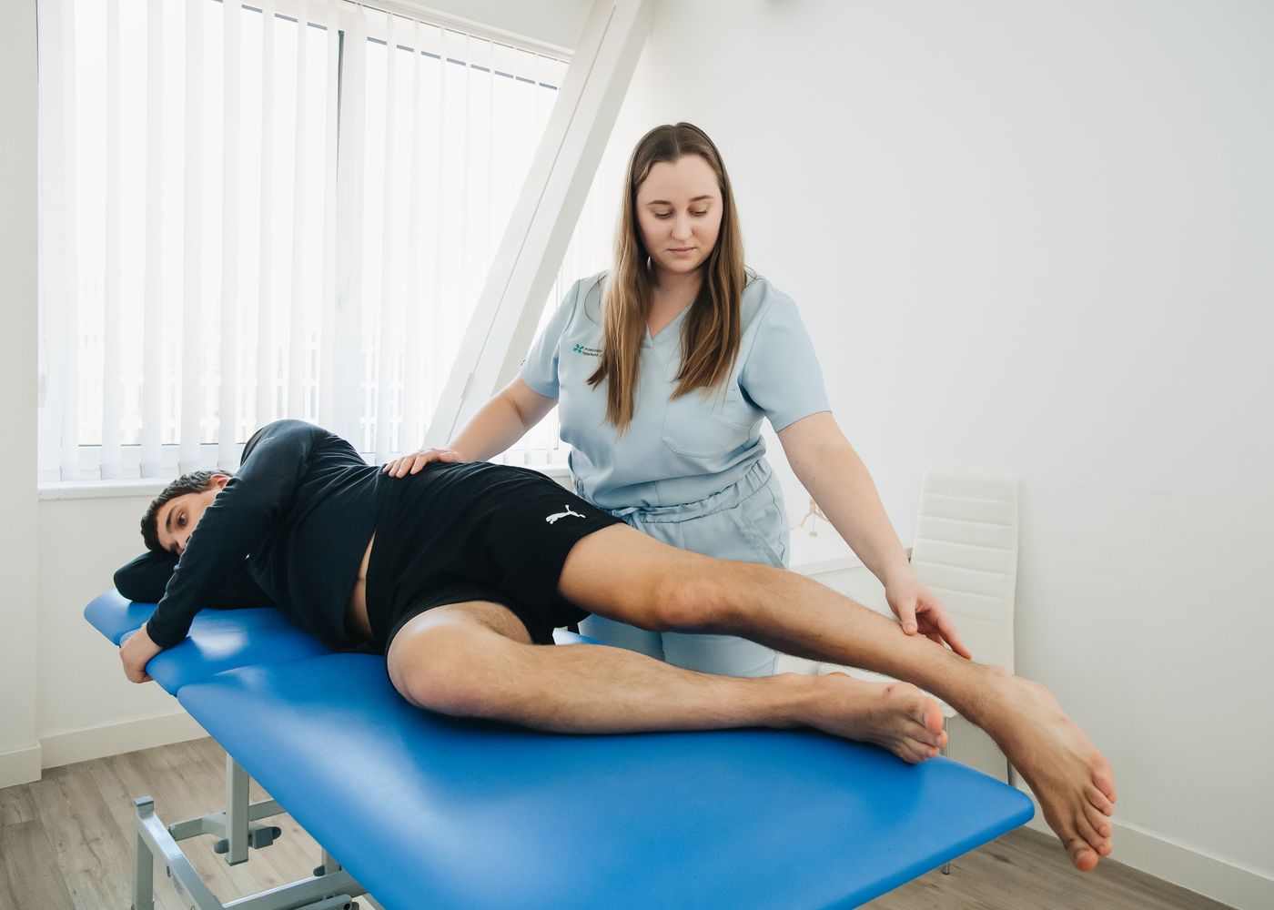 Une thérapeute accompagne une patiente pendant une séance de rééducation