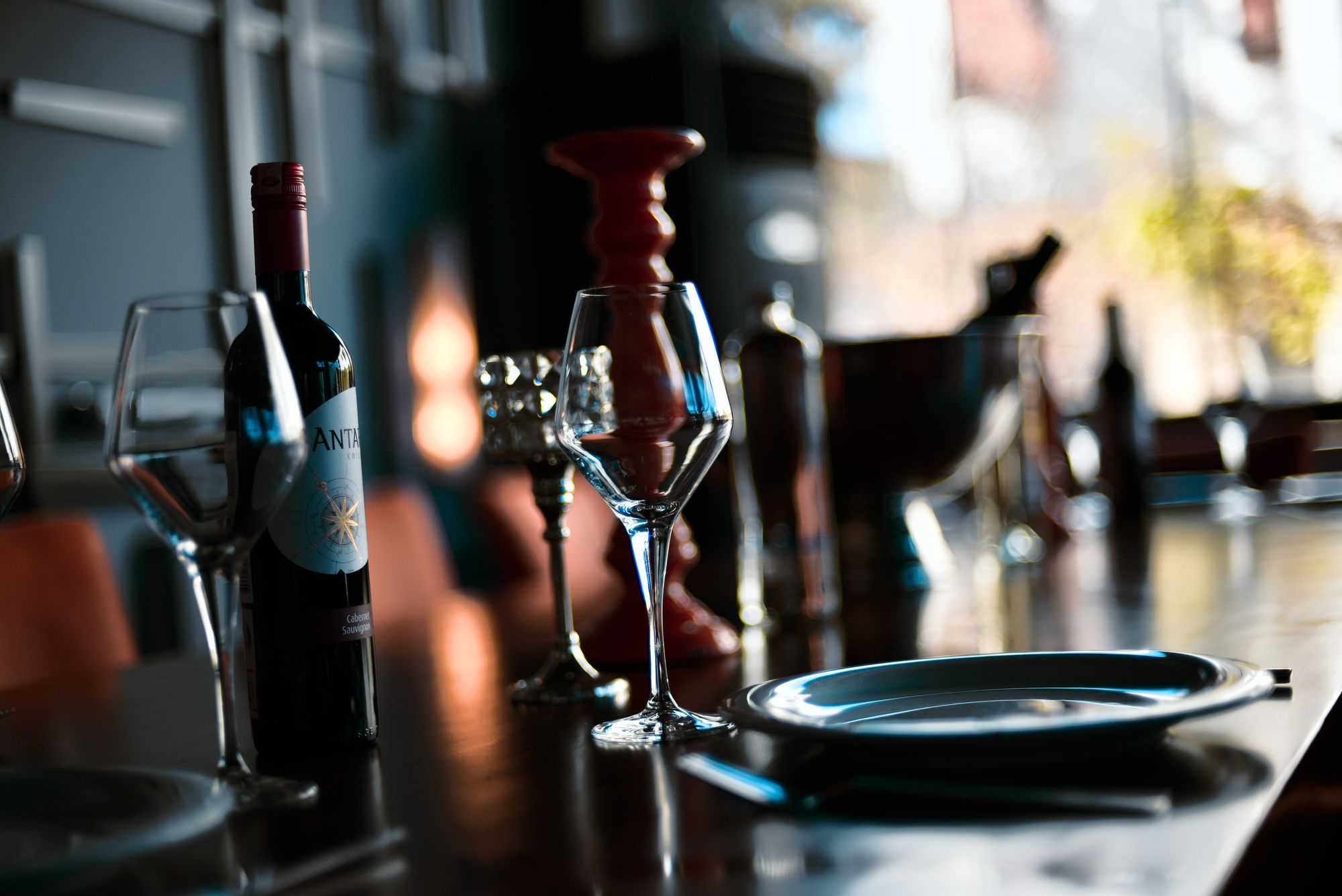 Verres taillés et service dressé dans la lumière du soir