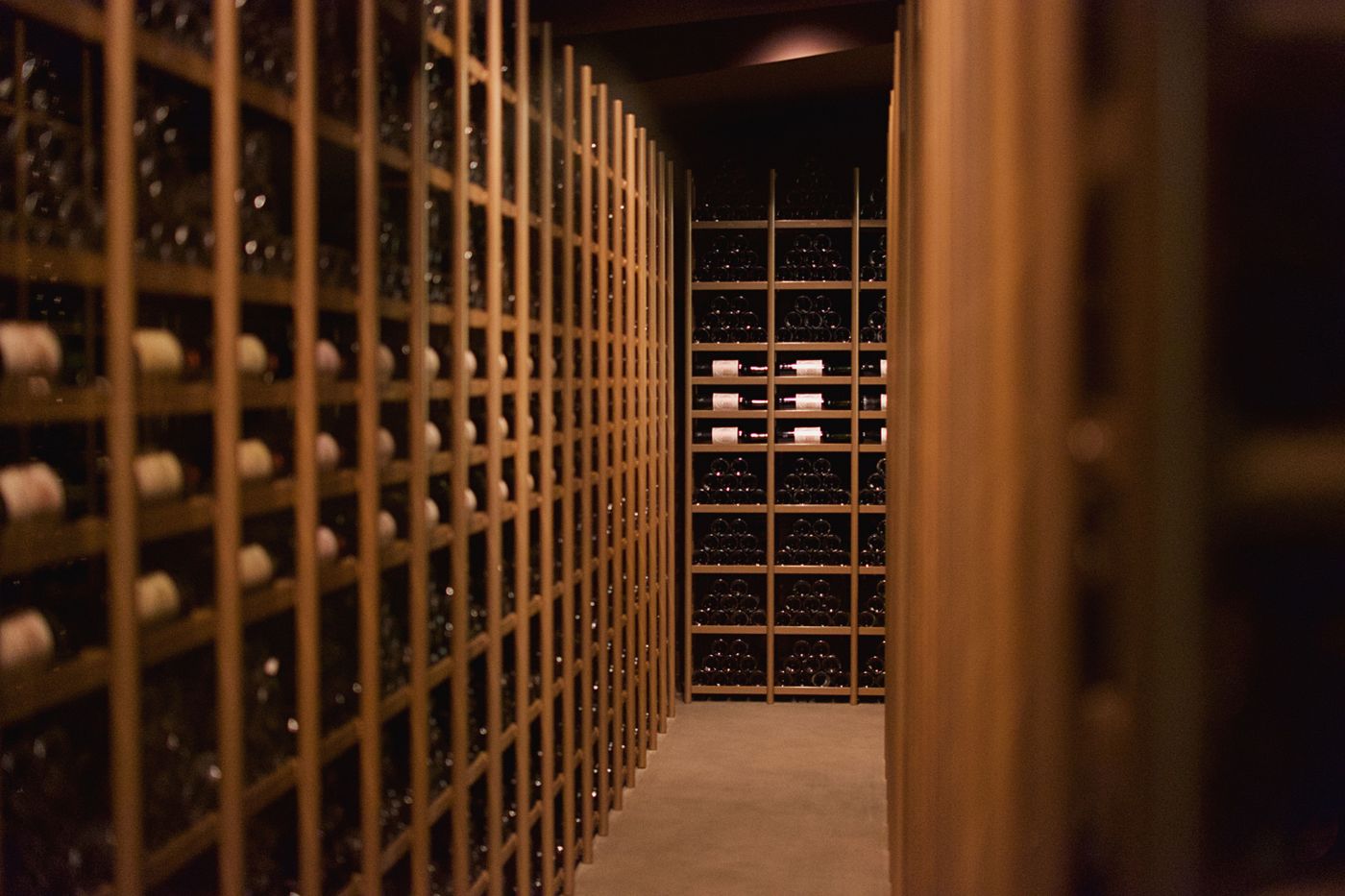 La cave voûtée, rangées de bouteilles à la lumière chaude