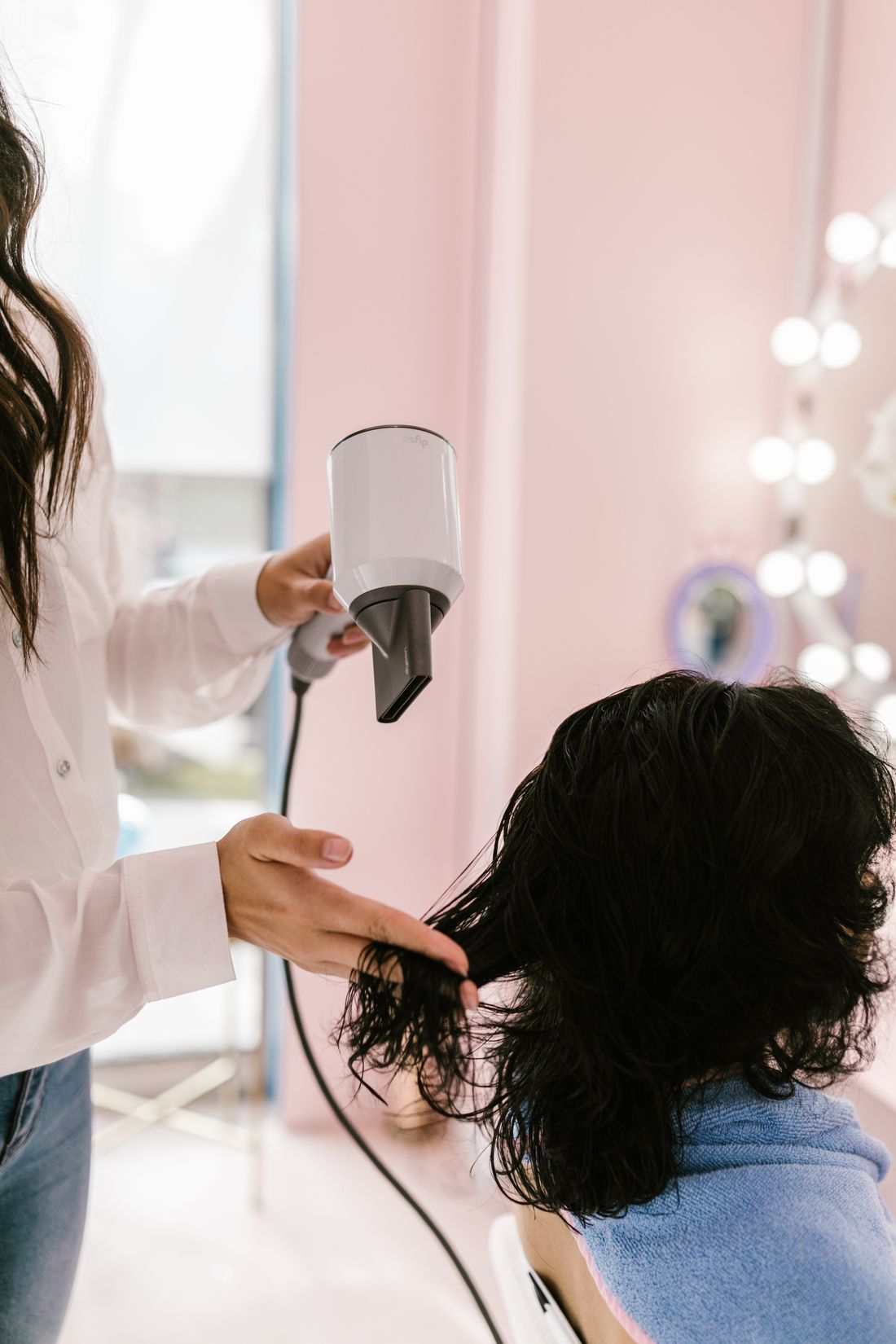 Une styliste du Studio Lumen réalise un brushing dans la lumière du matin