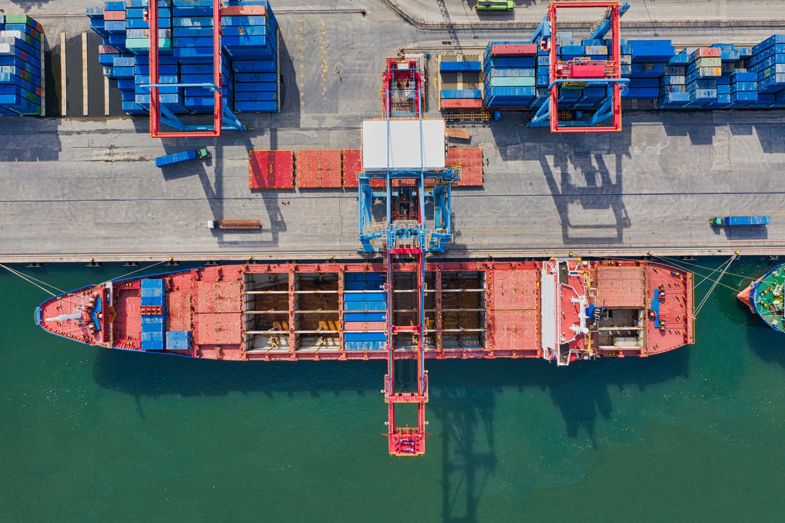 Container terminal at dawn, gantry cranes over stacked containers